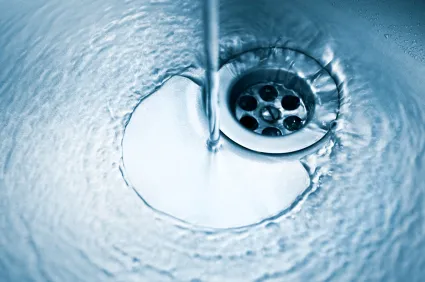 Water running down a stainless steel sink drain