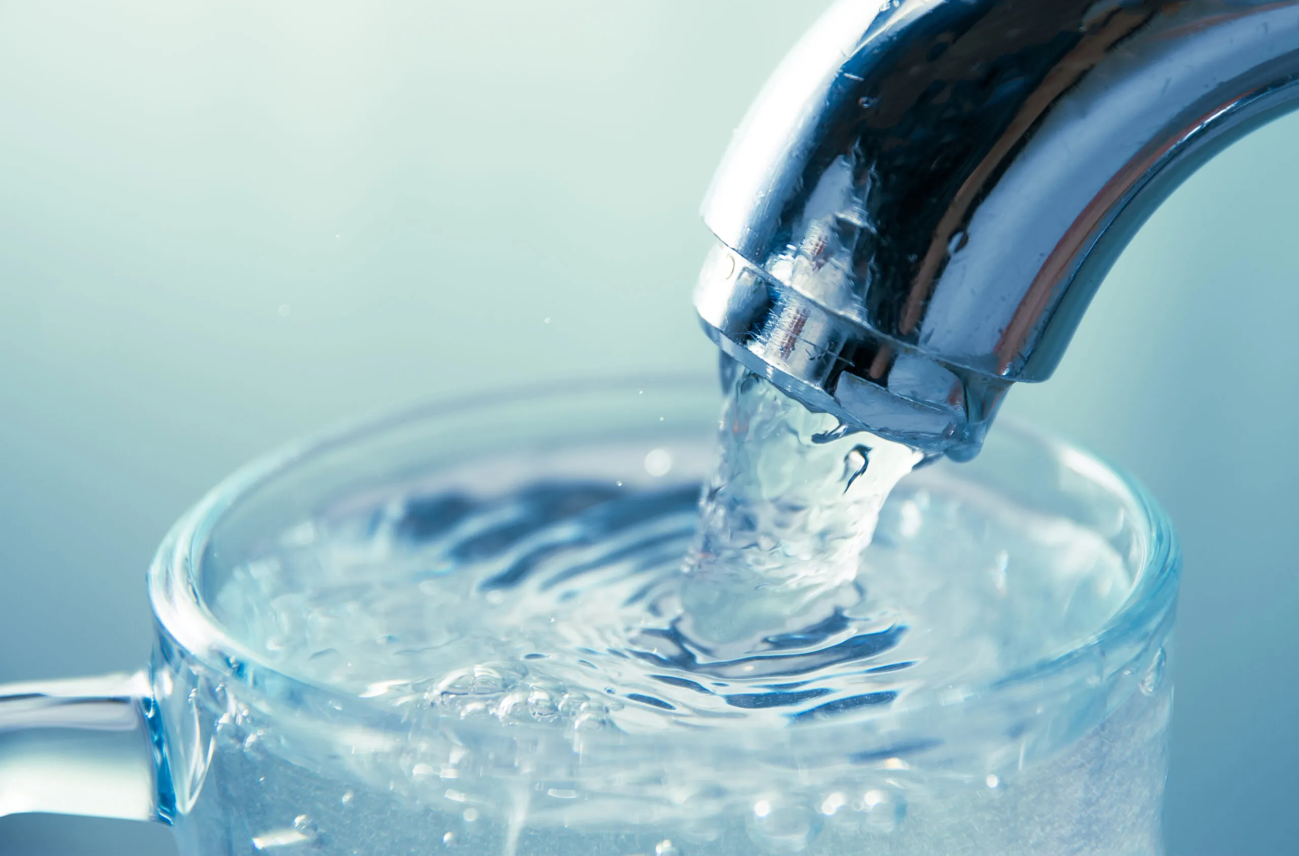 Water pouring from a faucet into a glass
